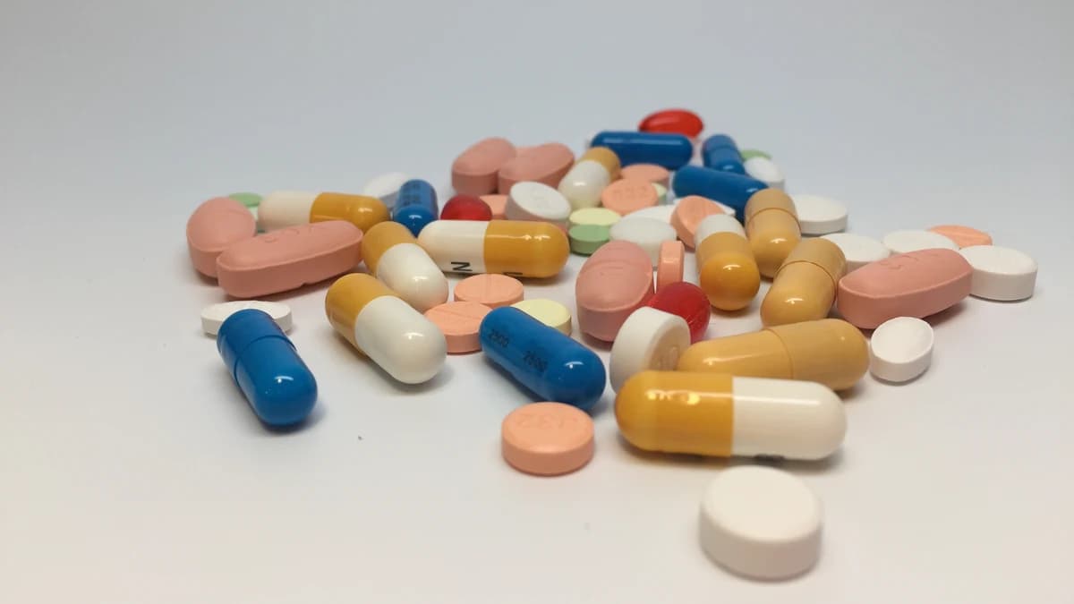 Comprimidos e cápsulas de medicamentos orais sobre uma superfície clara