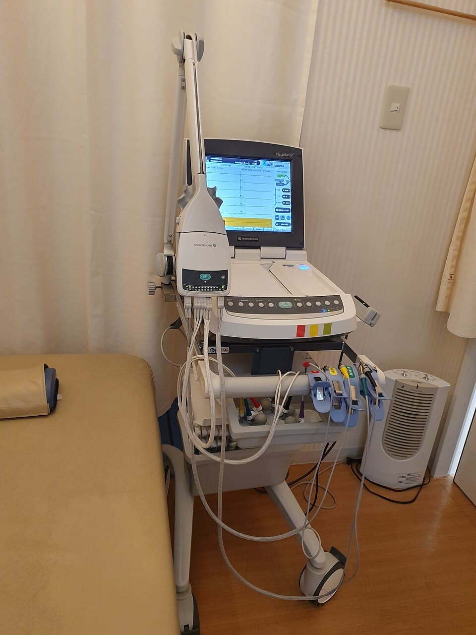 Fotografia vertical de um eletrocardiógrafo sobre uma mesa, usada como exemplo relacionado de dispositivo médico