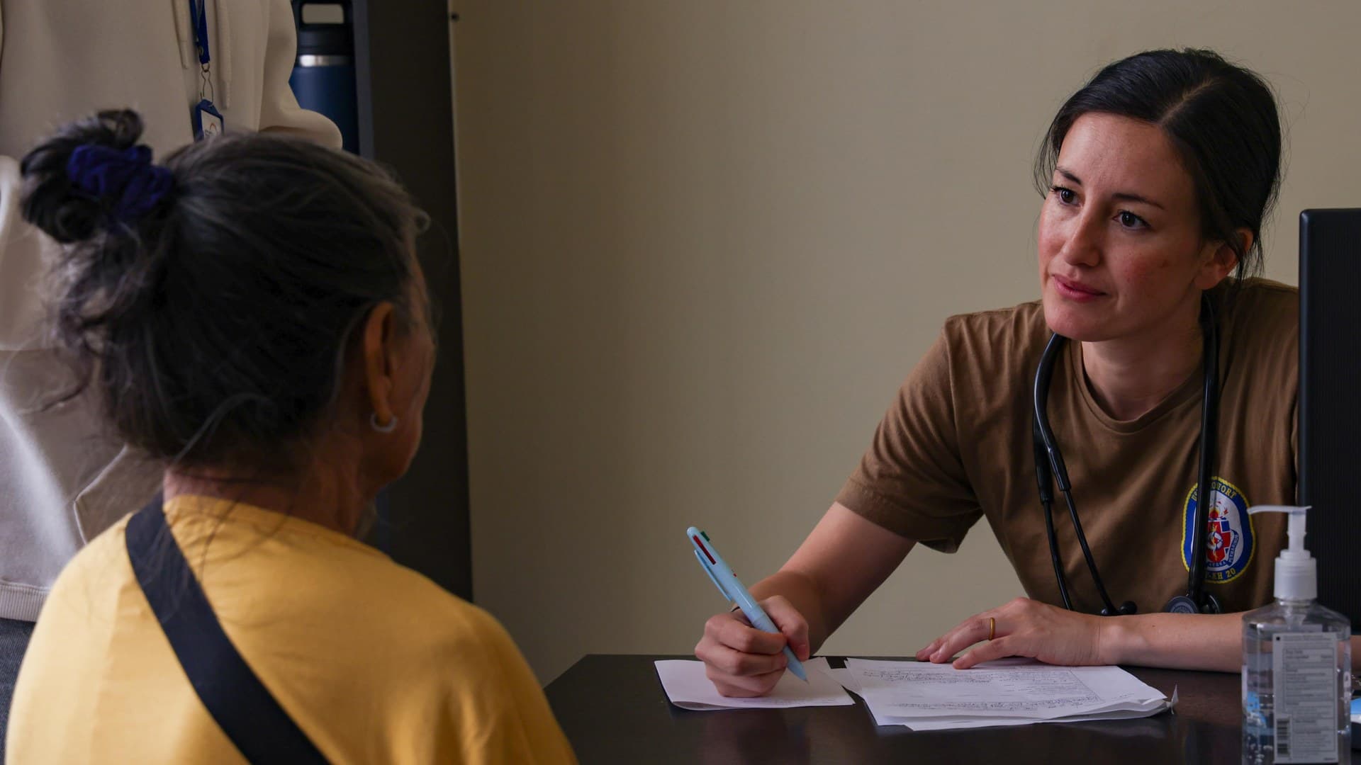 Cardiologista conversa com paciente durante uma consulta e faz anotações em papel
