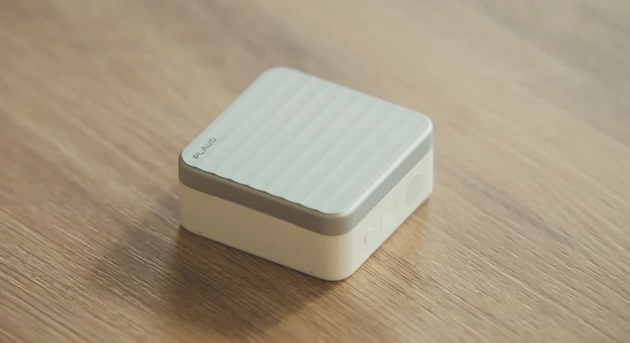 Estojo do Plaud One sobre uma mesa de madeira, no vídeo oficial de apresentação do produto