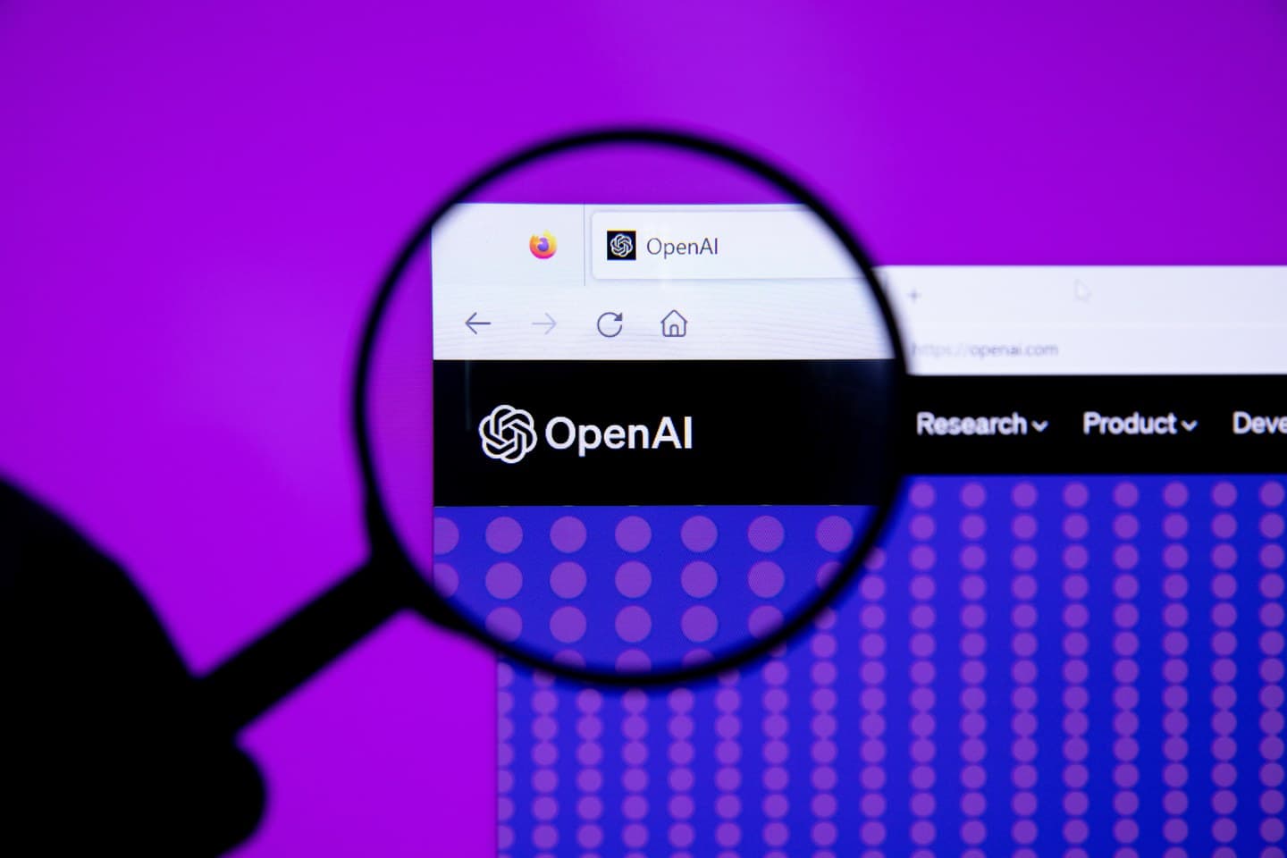 Fotografia de uma lupa diante da marca OpenAI exibida em uma tela